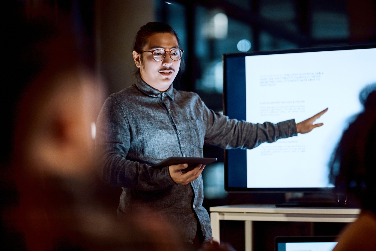 Shot of a young businessman delivering a presentation during a late night meeting at work