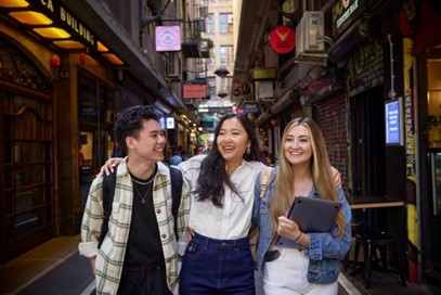 Three young international students walking down an iconic Melbourne laneway