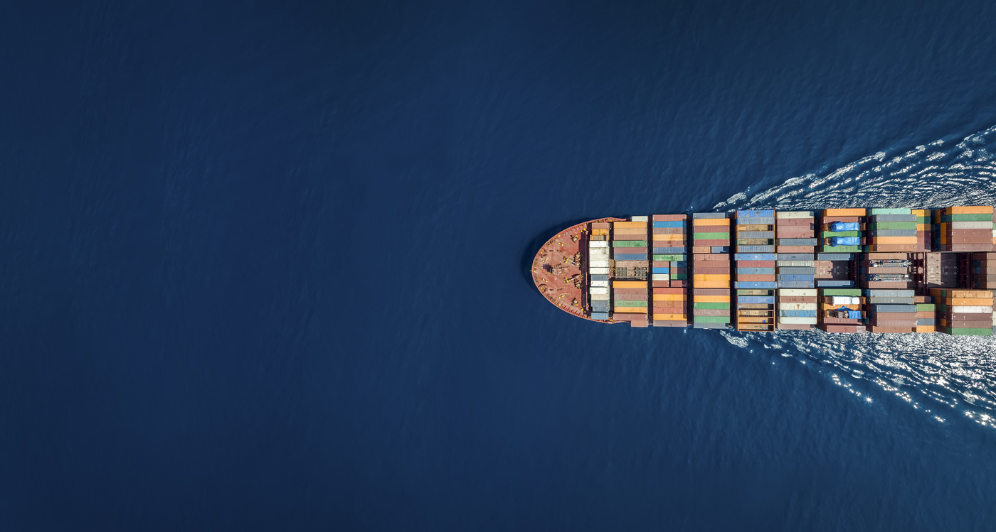 A cargo ship cruises along the ocean