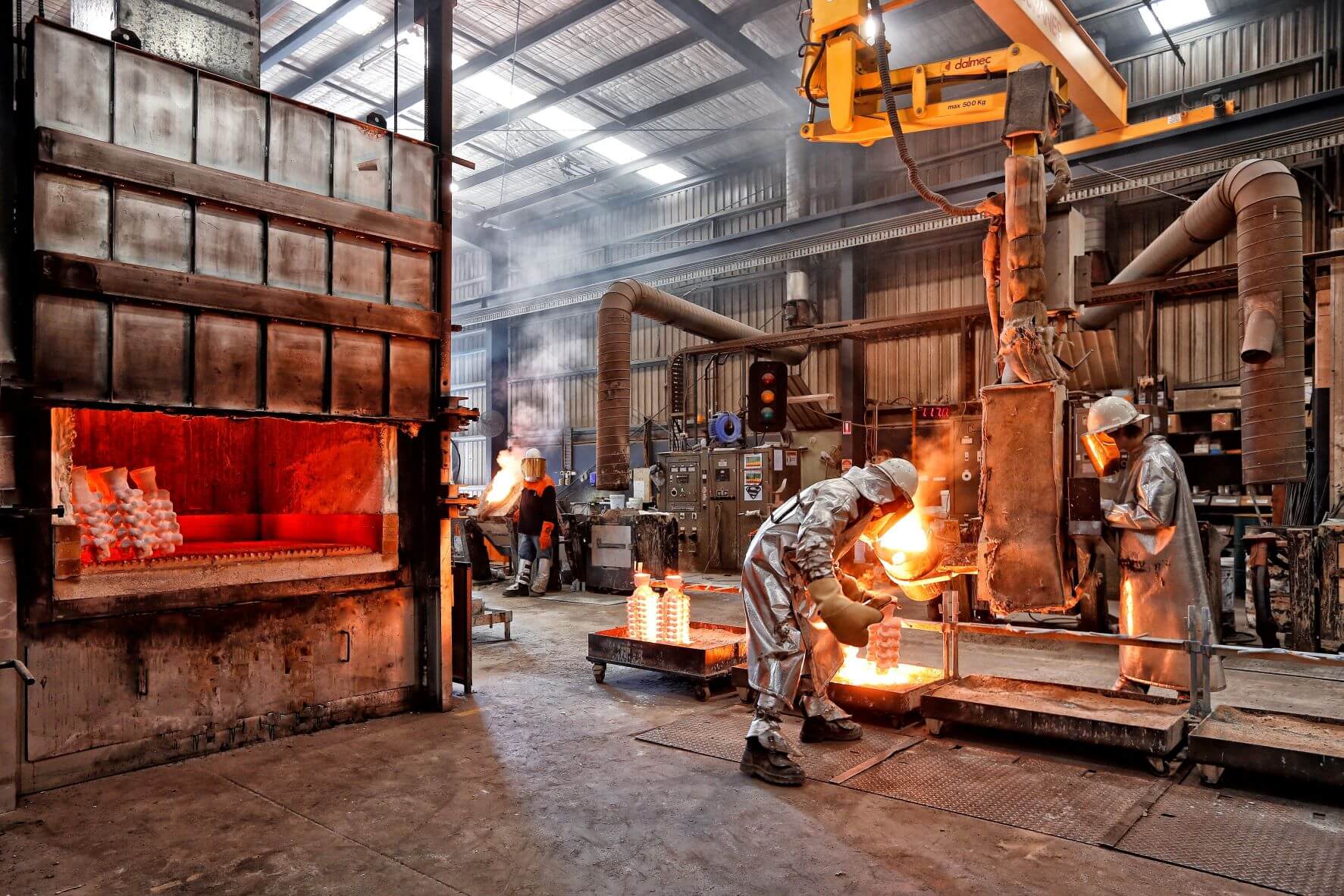 Workers in the foundry at AW Bell's manufaturing plant in protective gear