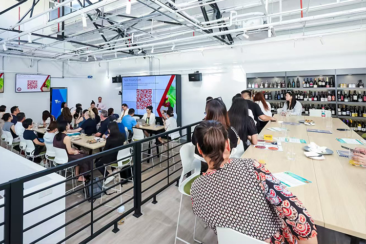 A Vic House workshop taking place in the new premises, with people sitting at tables listening to a presenter positioned at the front of the space